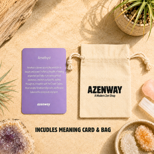 Amethyst crystal meaning card displayed beside an Azenway organic cotton drawstring gift bag with "Includes Meaning Card & Bag" text overlay. Set on a warm neutral background with natural crystals and botanical accents, showcasing the premium packaging included with every Amethyst purchase.