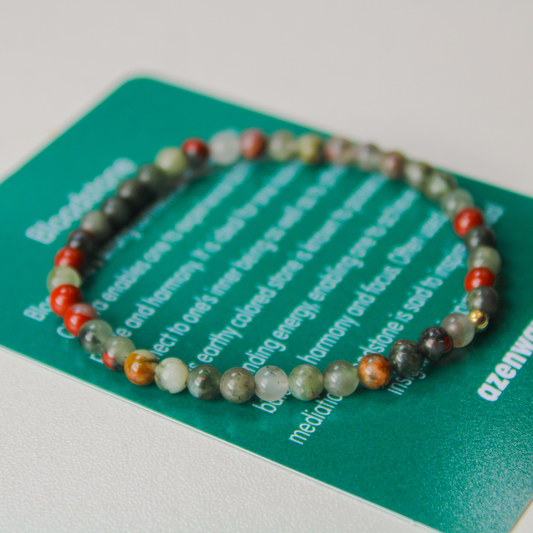 Close-up of Bloodstone gemstone bracelet resting on Azenway meaning card.