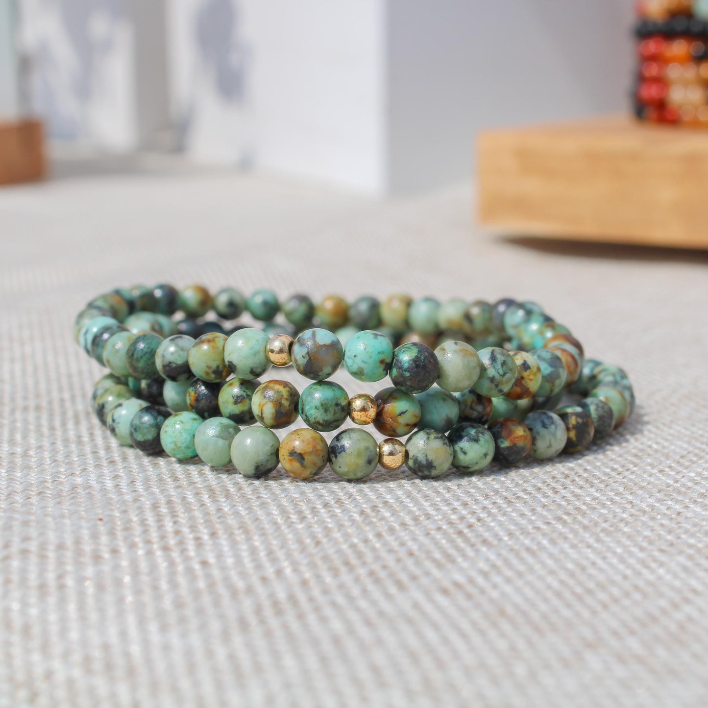 Stack of African Turquoise gemstone bracelets with gold-filled accents shown in natural light.