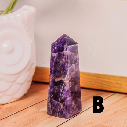 Amethyst crystal tower labeled B polished purple stone point photographed on wooden surface