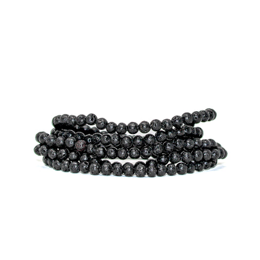 Close-up of stacked 4mm black lava stone beads showing their natural volcanic texture.