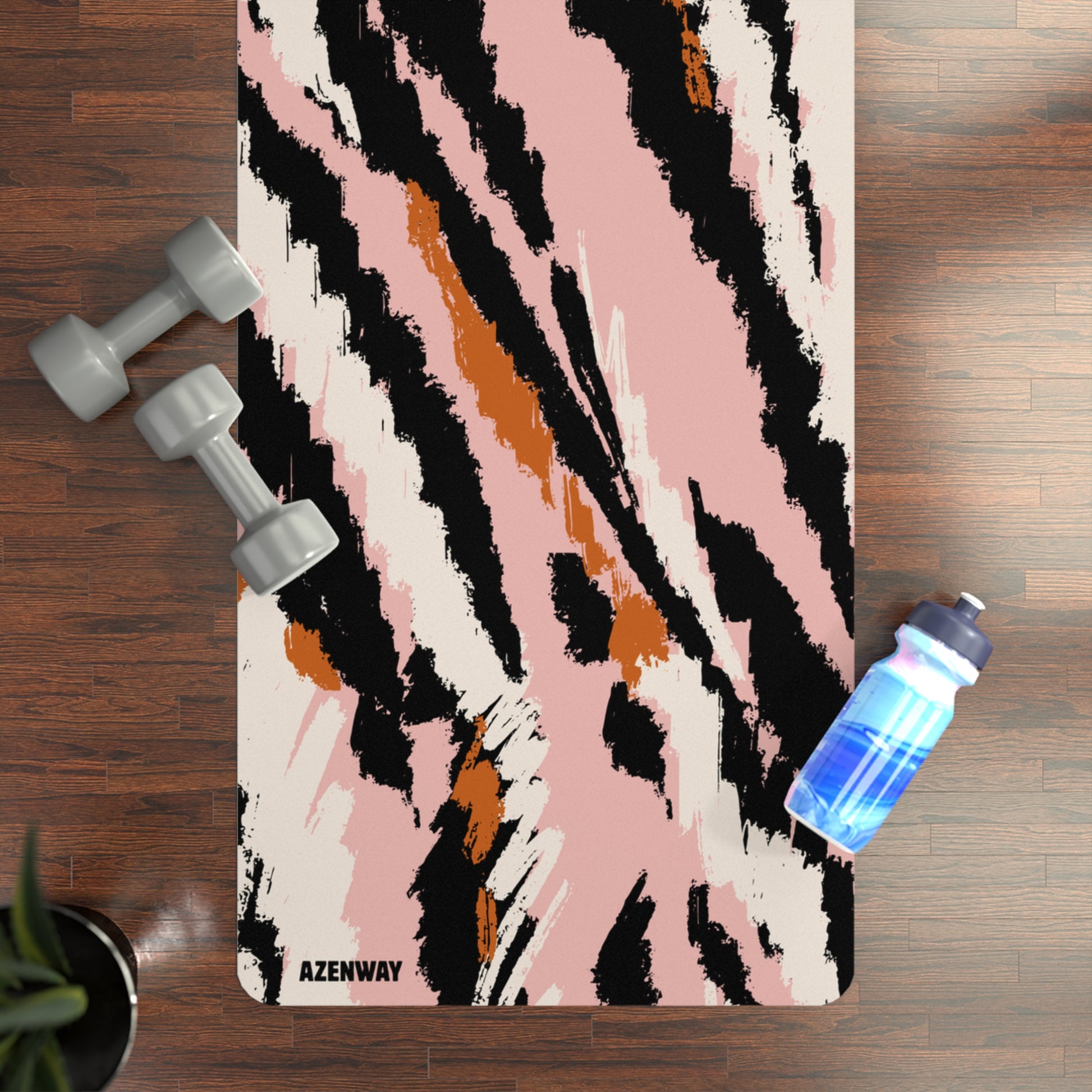 Yoga mat with abstract design on a wooden floor with dumbbells and a water bottle.