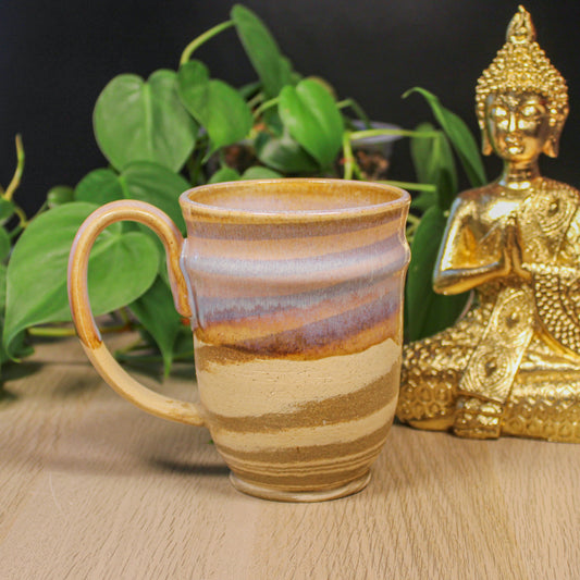 Side view of handmade ceramic swirl mug with handle, layered glaze in warm earth tones by Emma Stewart