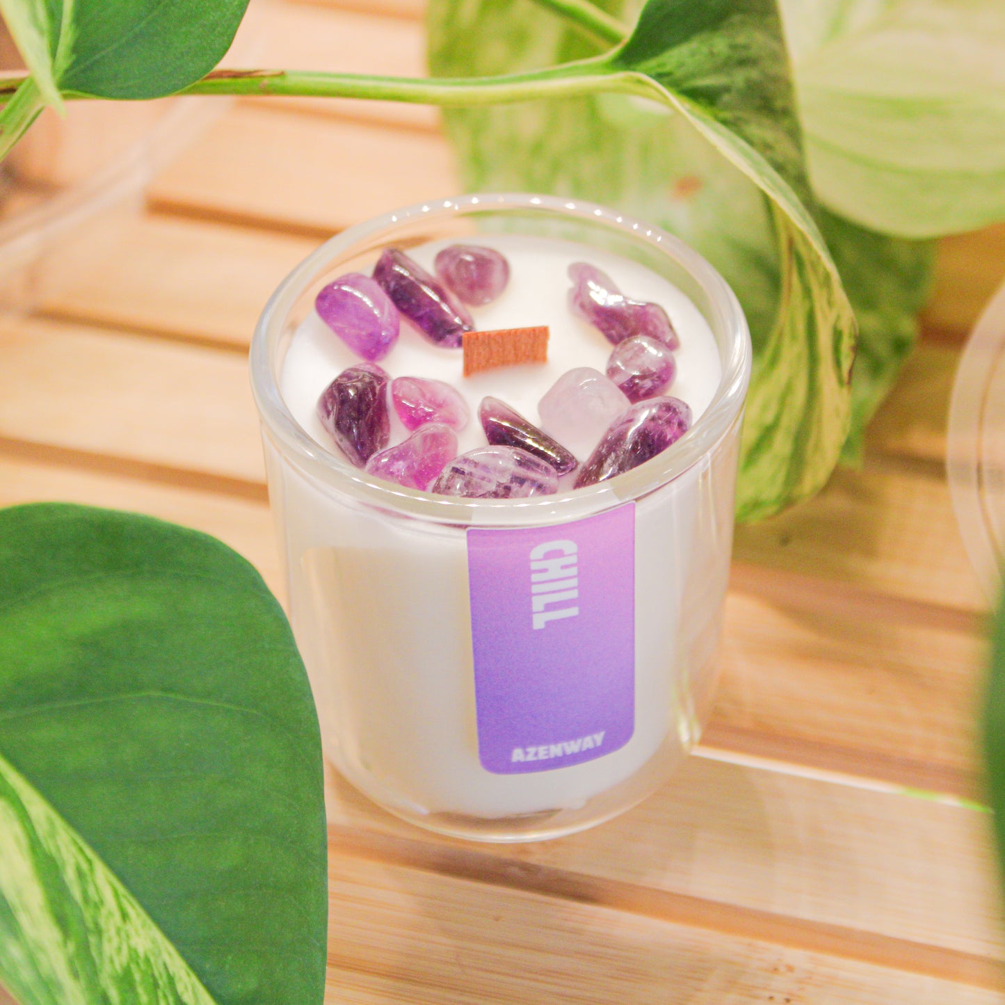 Mini amethyst crystal candle with essential oil blend and wooden wick styled with houseplants