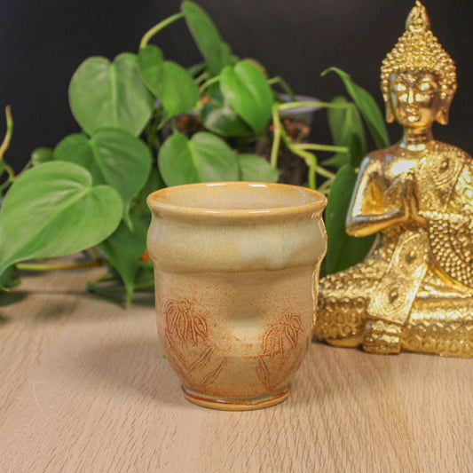 Side view of handmade ceramic floral cup with thumb indent, botanical pattern and soft earthy glaze by Emma Stewart