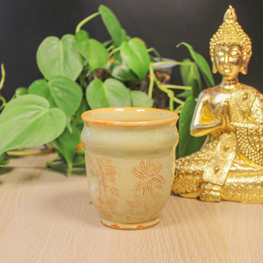 Handmade ceramic flower cup by Emma Stewart with botanical pattern and warm tan glaze, artisan pottery