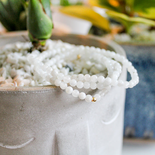 Close-up of genuine Moonstone bracelets with a 14k gold-filled accent bead resting on a planter.