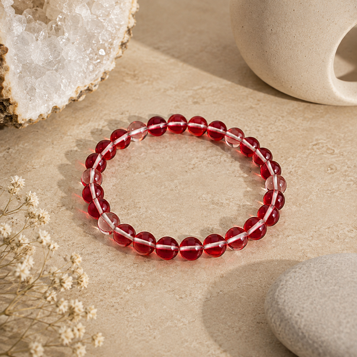 Handmade Red Mystic Glass stretch bracelet featuring premium 6mm iridescent glass beads on a warm neutral stone surface with natural crystals and zen-inspired décor. Lightweight bracelet shimmers with rich ruby red tones and luminous reflections.