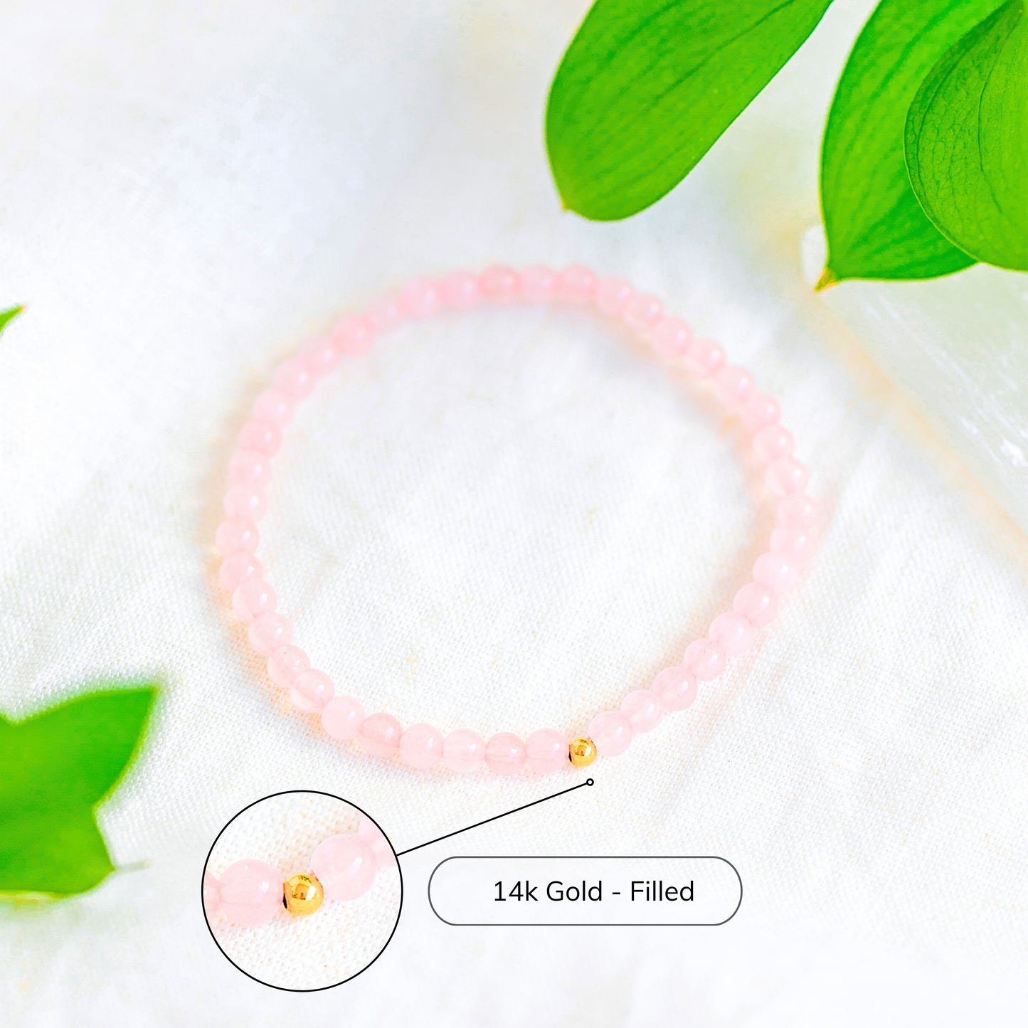 Rose Quartz 4mm beaded bracelet with a highlighted close-up of the 14k gold-filled accent bead, displayed on white fabric with greenery.