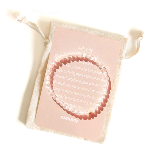 Genuine 4mm Selenite crystal bracelet with a gold-filled bead displayed on an Azenway meaning card and linen pouch.