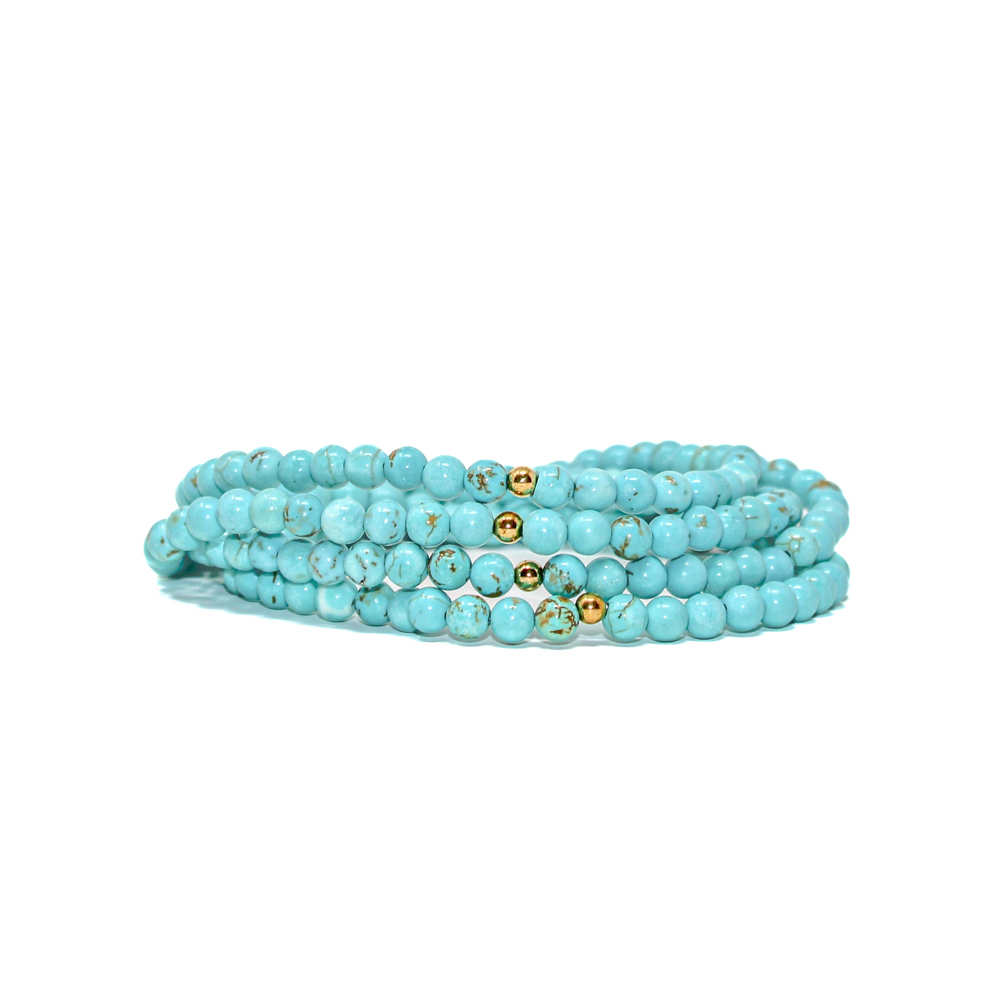 Multiple turquoise gemstone bracelets stacked together, showing natural matrix patterns and gold-filled accent beads.