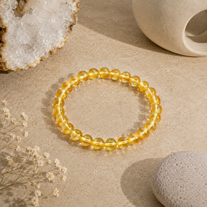 Handmade Yellow Mystic Glass stretch bracelet featuring premium 6mm iridescent glass beads on a warm neutral stone surface with natural crystals and zen-inspired décor. Lightweight bracelet shimmers with vibrant golden-yellow tones and luminous reflections.