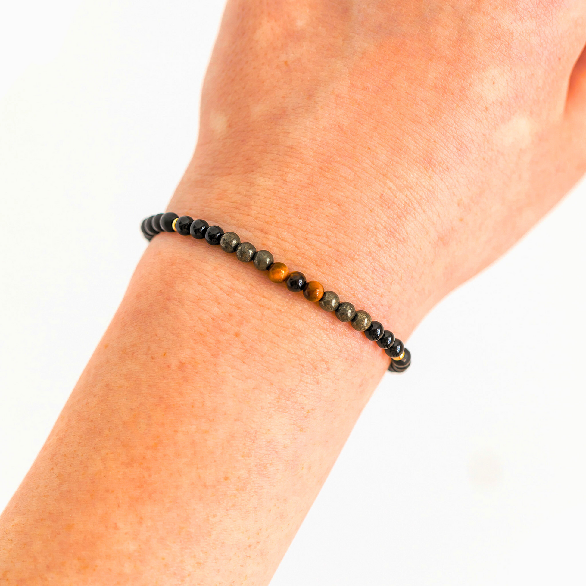 Protection bracelet worn on wrist showing Black Onyx, Pyrite, Tiger’s Eye and Black Tourmaline bead arrangement