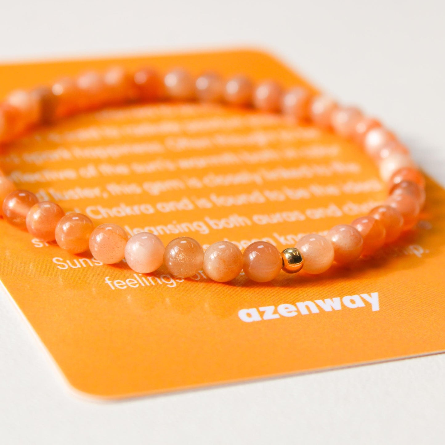 Close-up of Sunstone gemstone bracelet with gold-filled accent on Azenway meaning card.