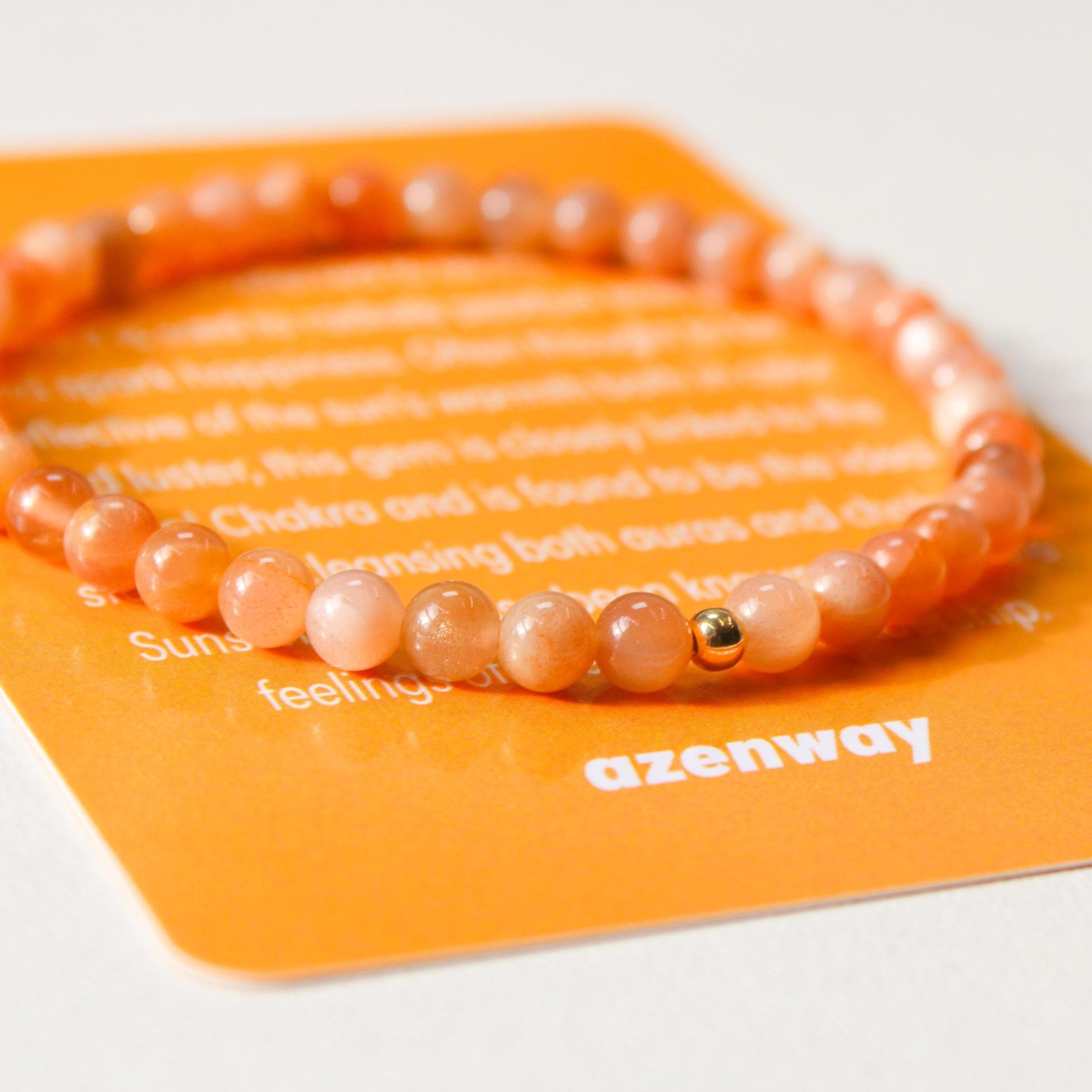 Close-up of Sunstone gemstone bracelet with gold-filled accent on Azenway meaning card.